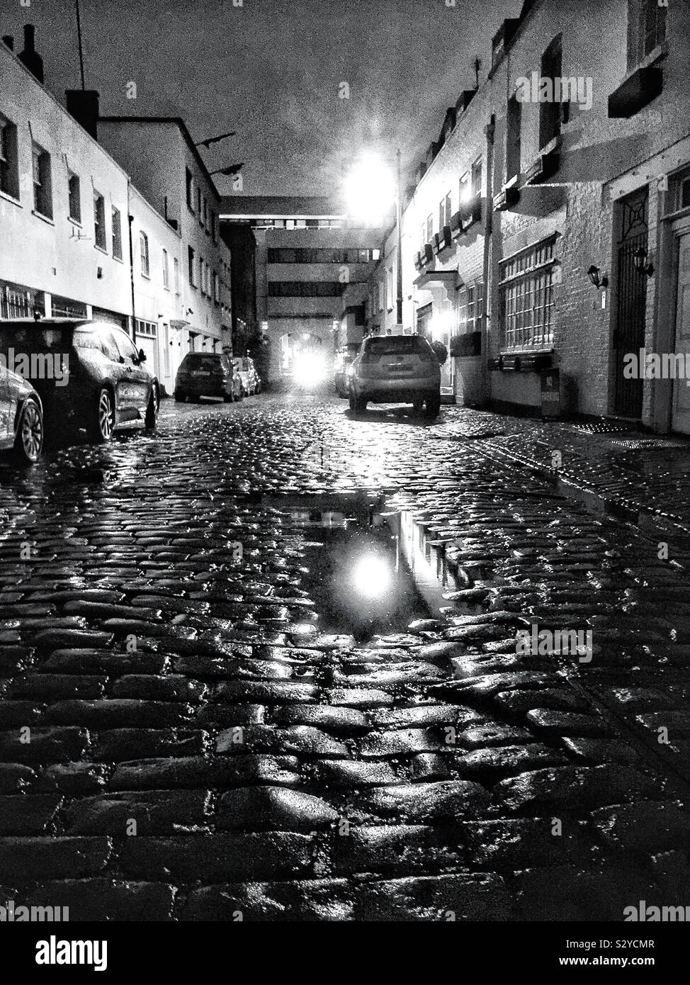 Eine gepflasterte Straße in Belgravia, London in der Nacht nach dem Regen. Stockfoto