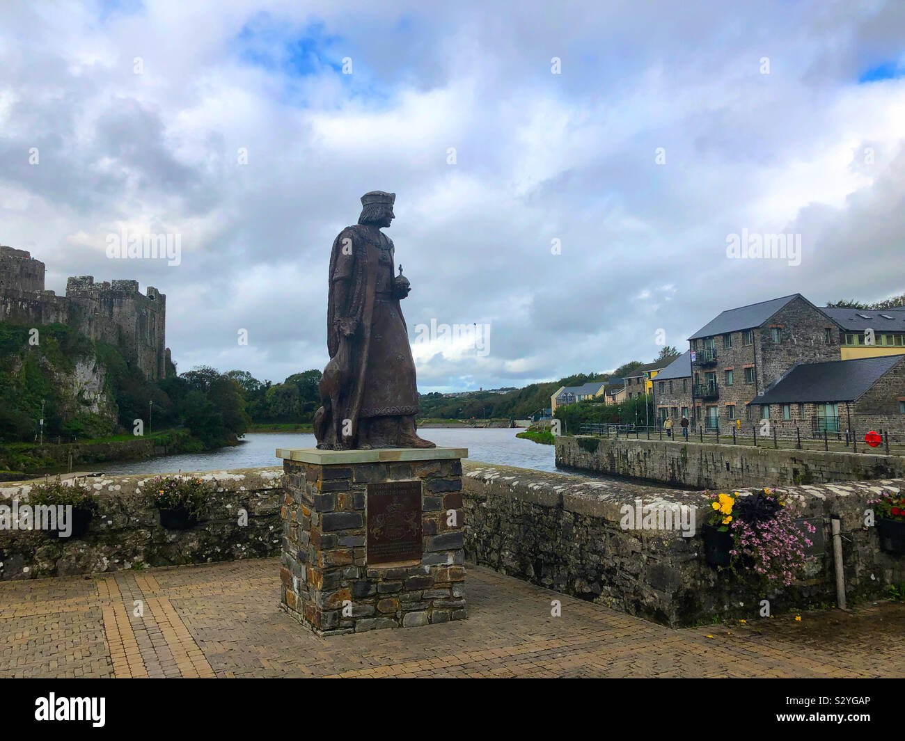 Die Statue von König Heinrich VII. von Schloss Teich, und mit Pembroke Castle auf der linken Seite an Pembroke, Pembrokeshire, Wales, UK. - Smartphone-aufgenommenes Stockfoto