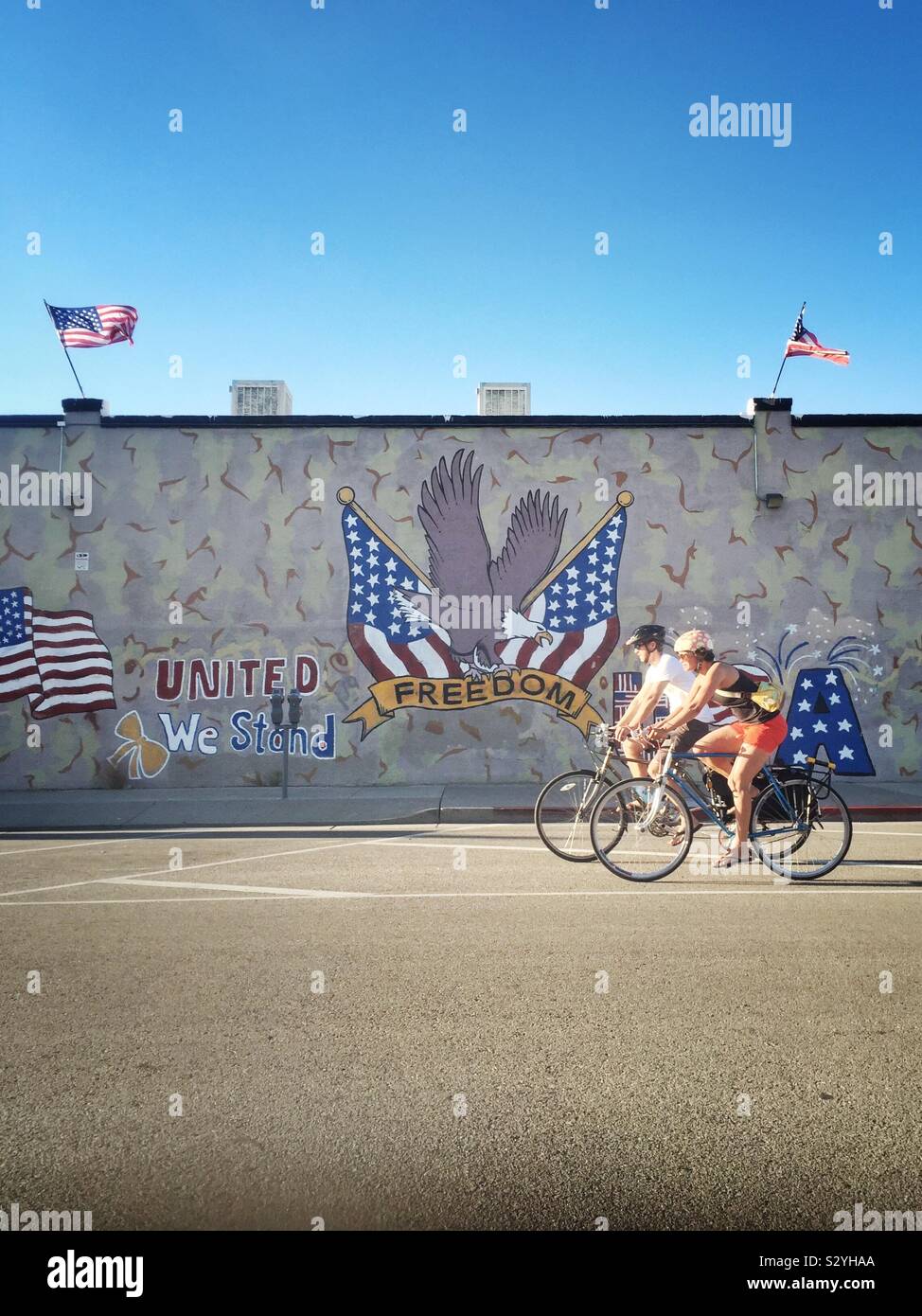Paar Radfahren vor dem Hintergrund einer patriotischen Murales in Tucson, Arizona Stockfoto