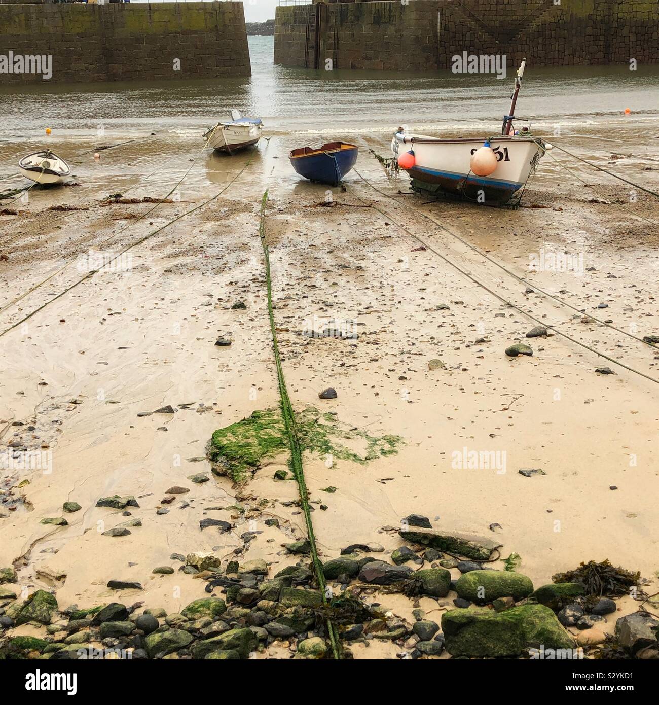 Kleine Boote im Mousehole Hafen bei Ebbe, November. - Smartphone-aufgenommenes Stockfoto