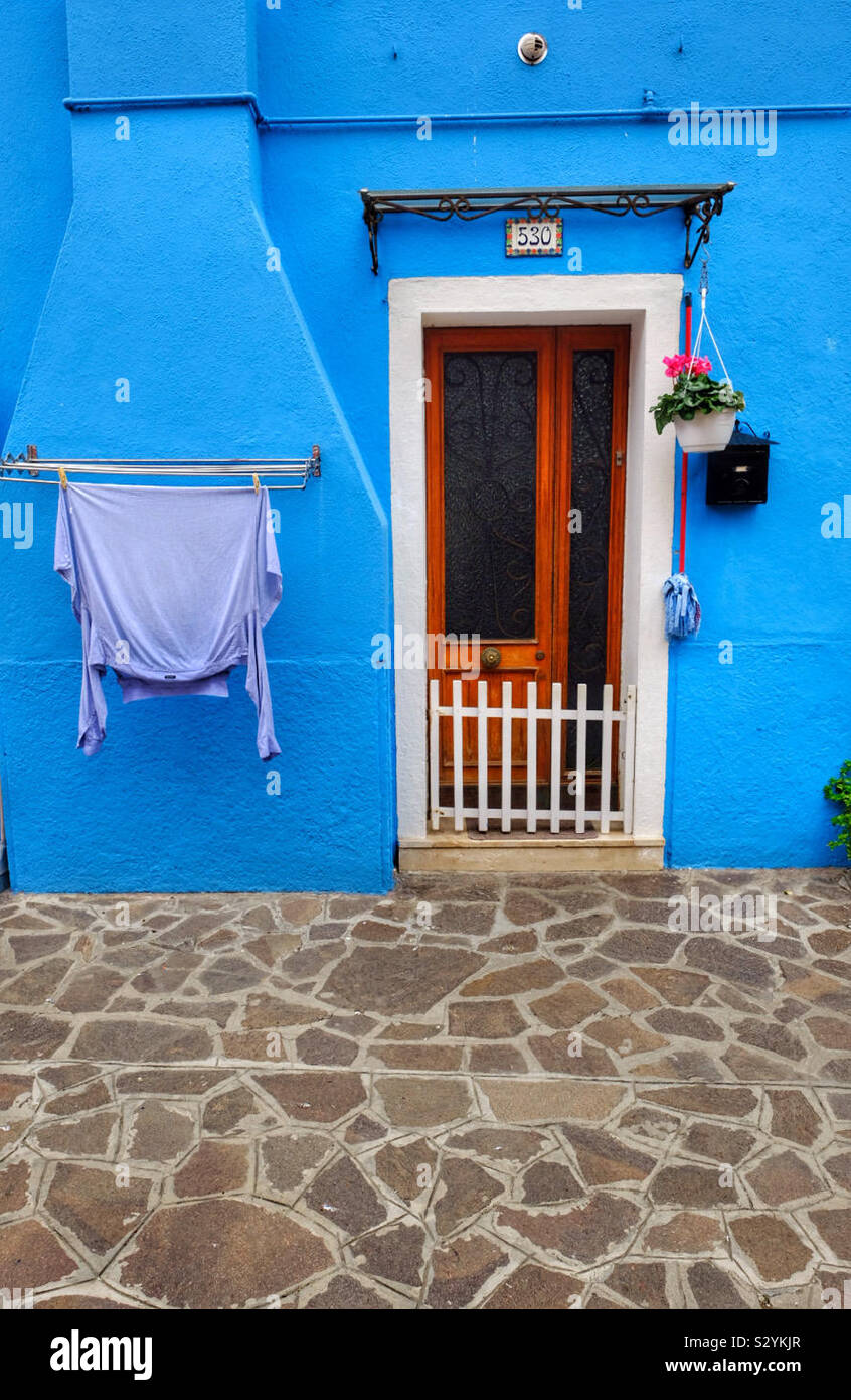 Eine bunte Wand mit einer Tür und Waschmaschine - Smartphone-aufgenommenes Stockfoto