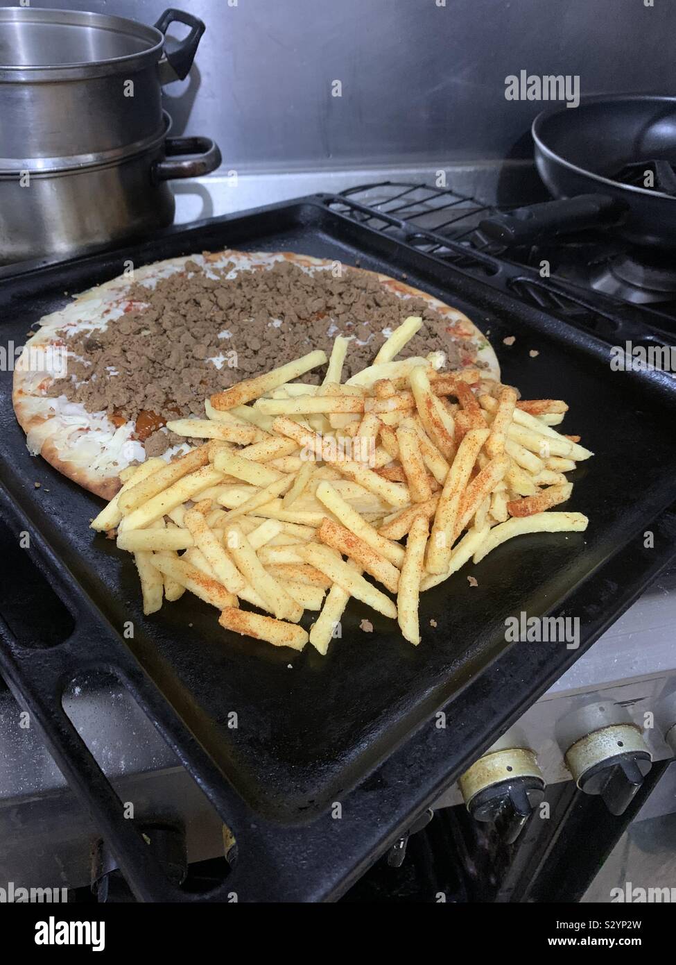 Eine Margherita pizza garniert mit Pommes frites meatfree Quorn mit Paprika Hackfleisch. 🍕 Zeitraum in den Backofen zu gehen. Stockfoto