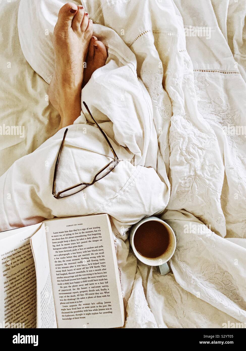 Tee und Buch im Bett Stockfoto