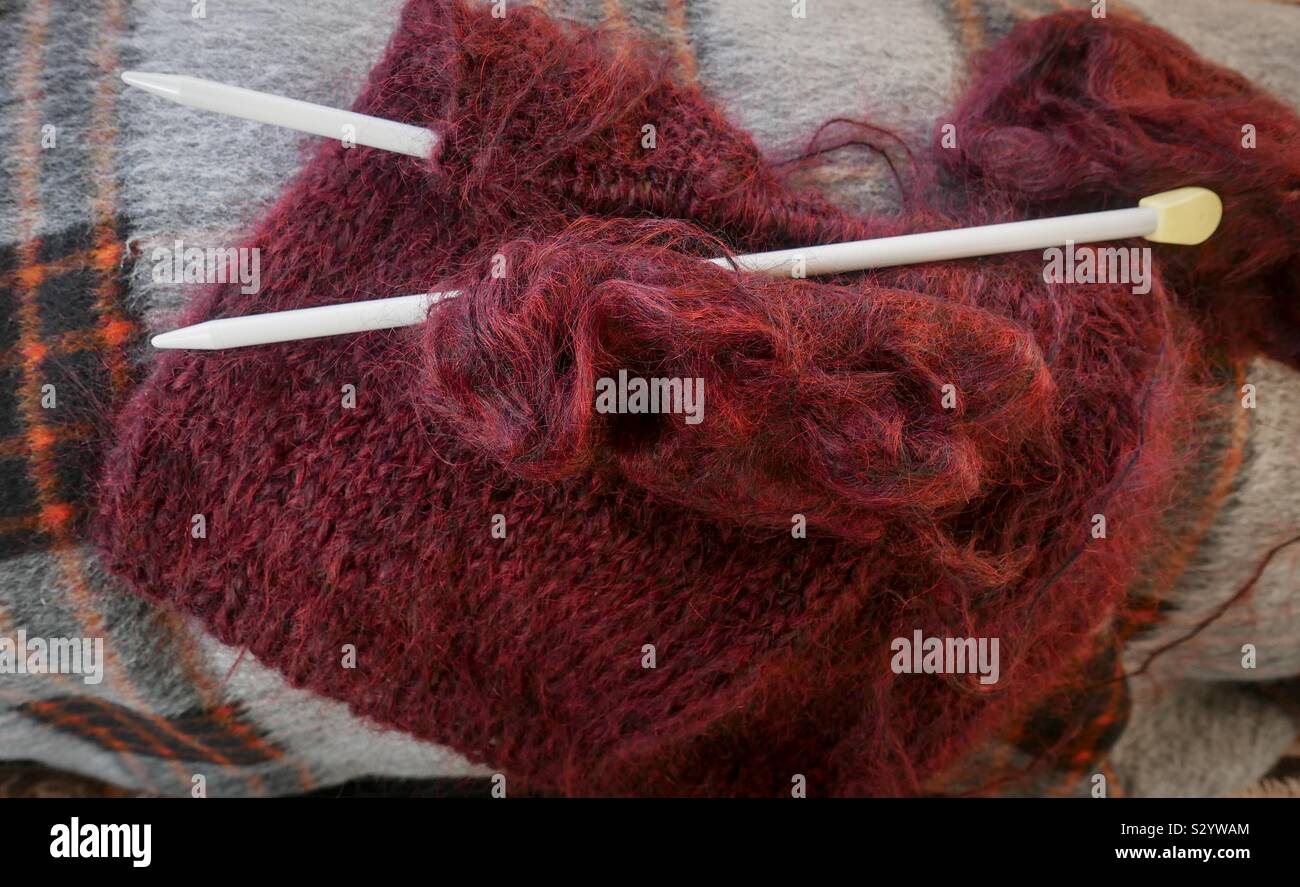 Stricken, ein Winter mohair Pullover. Stricken, Nadeln und Wolle auf eine geprüfte Decke. Stockfoto