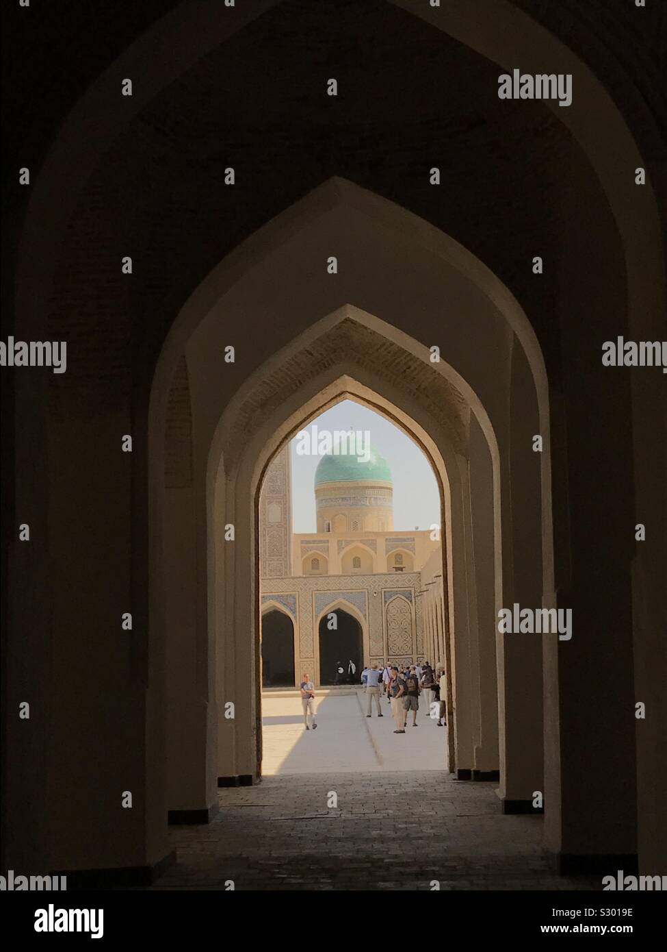 Blick von der schattigen Galerien in den sonnigen Innenhof der Po-i-Kalyan islamischen Komplex in Buchara, Usbekistan. Stockfoto