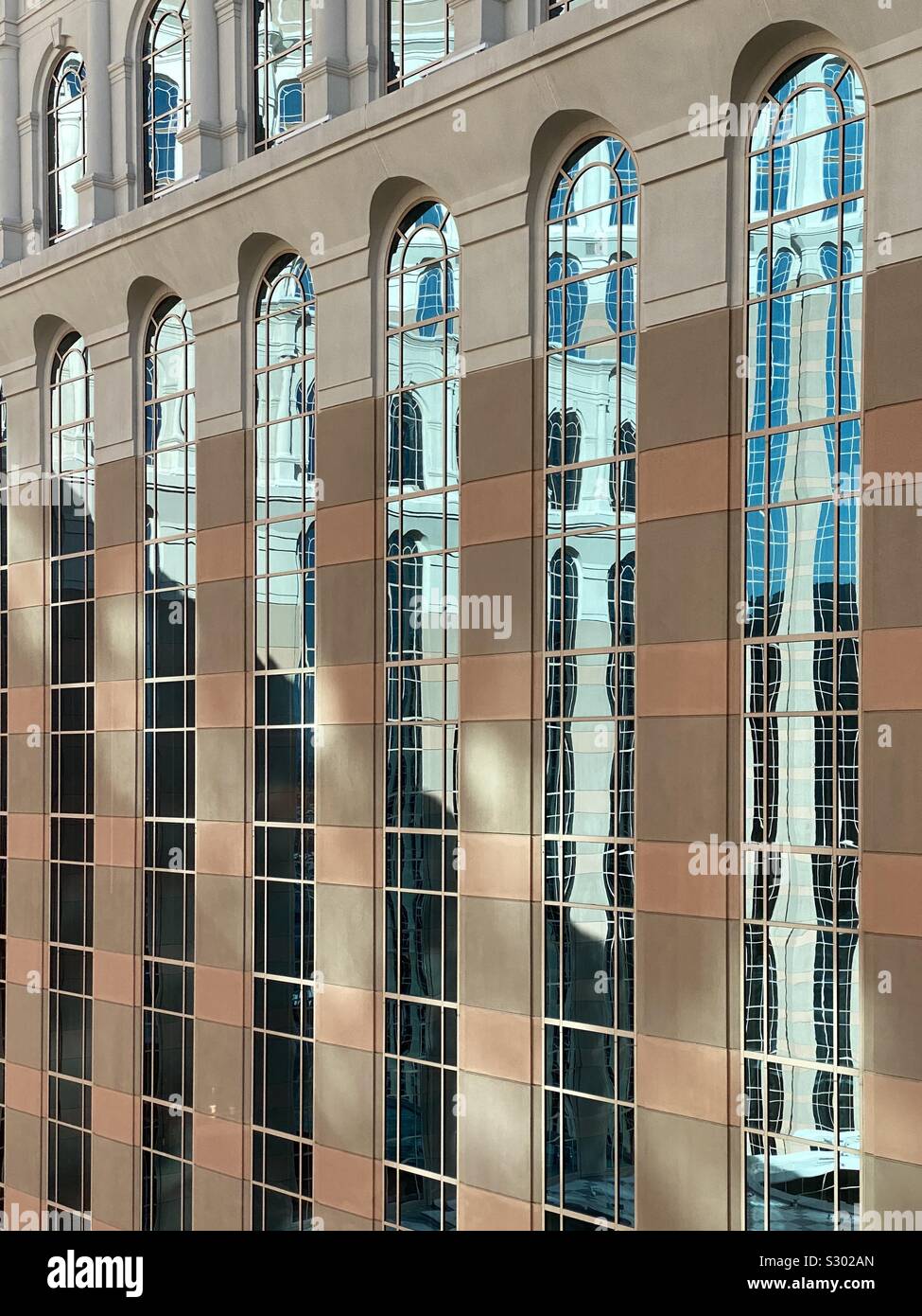 Reflexionen über ein sehr hohes Gebäude mit Glasfenstern - Smartphone-aufgenommenes Stockfoto