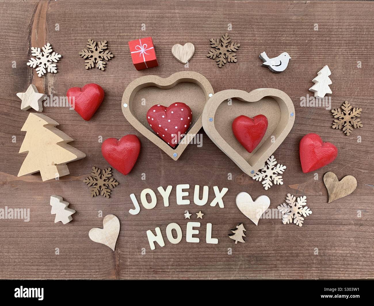Joyeux Noël, Französisch Frohe Weihnachten Nachricht mit Dekorationen aus Holz Stockfoto