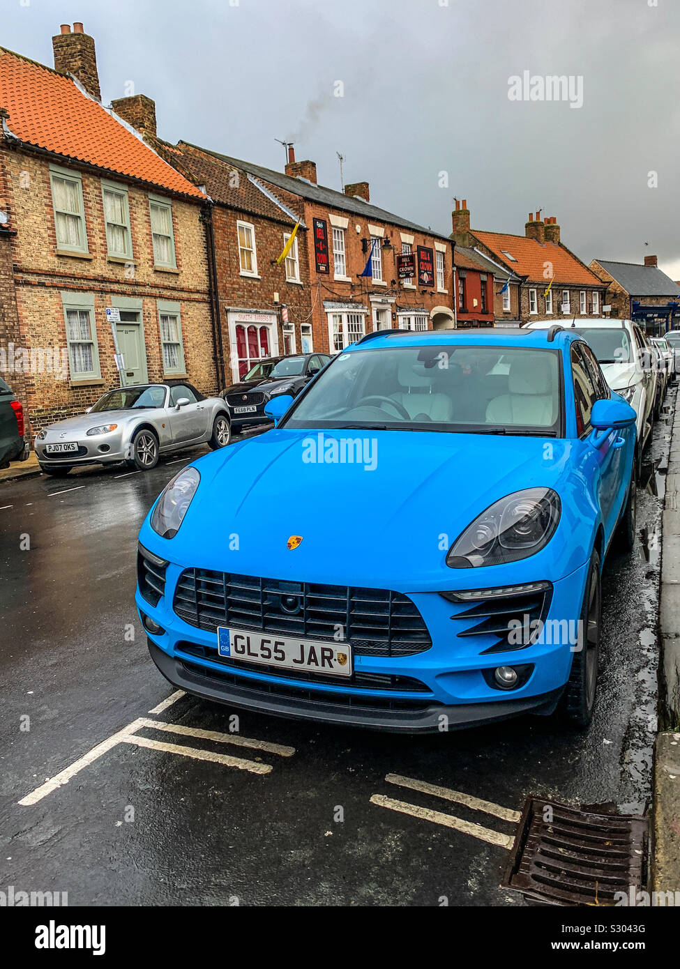 Miami blau Porsche Macan SUV in städtischen Dorfstraße geparkt Stockfoto