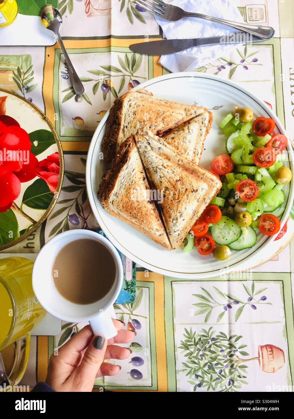 Gesunde vegetarische Mittagessen machte ich für meinen Partner. Brot mit Käse und Tomaten garniert mit frischen Salat mit Sellerie, Tomaten, Gurken, geröstet, gefüllte Oliven und Frühlingszwiebeln. London Stockfoto