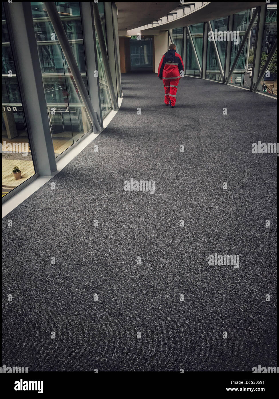 Mann Kreuzung Sky Bridge im Cape Town International Convention Centre, Südafrika. - Smartphone-aufgenommenes Stockfoto