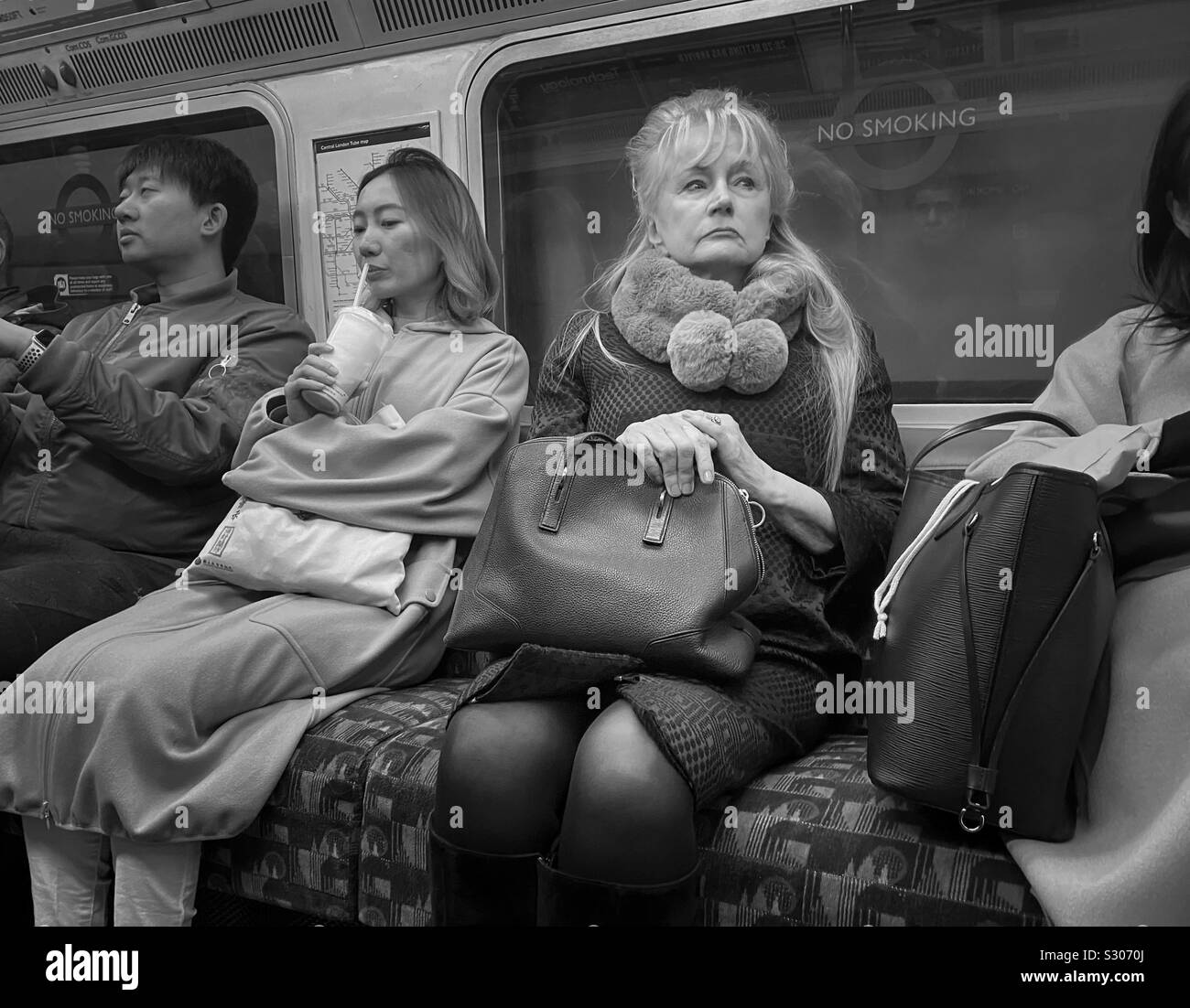 Leute in einer geschäftigen U-Bahn in London, die Dame suchte den perfekten Ort, um ein Foto zu machen Stockfoto