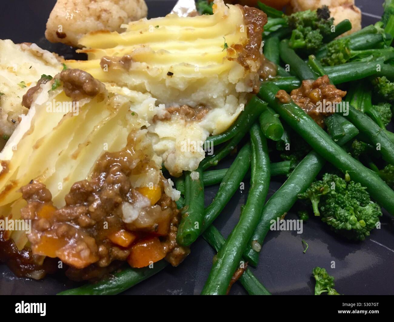 Cottage Pie mit Gemüse. Kartoffelbrei, Hackfleisch, Fleisch, Karotten, Zwiebeln, grüne Bohnen, Brokkoli und Spargel. Traditionelle britische hausgemachte Speisen. Stockfoto