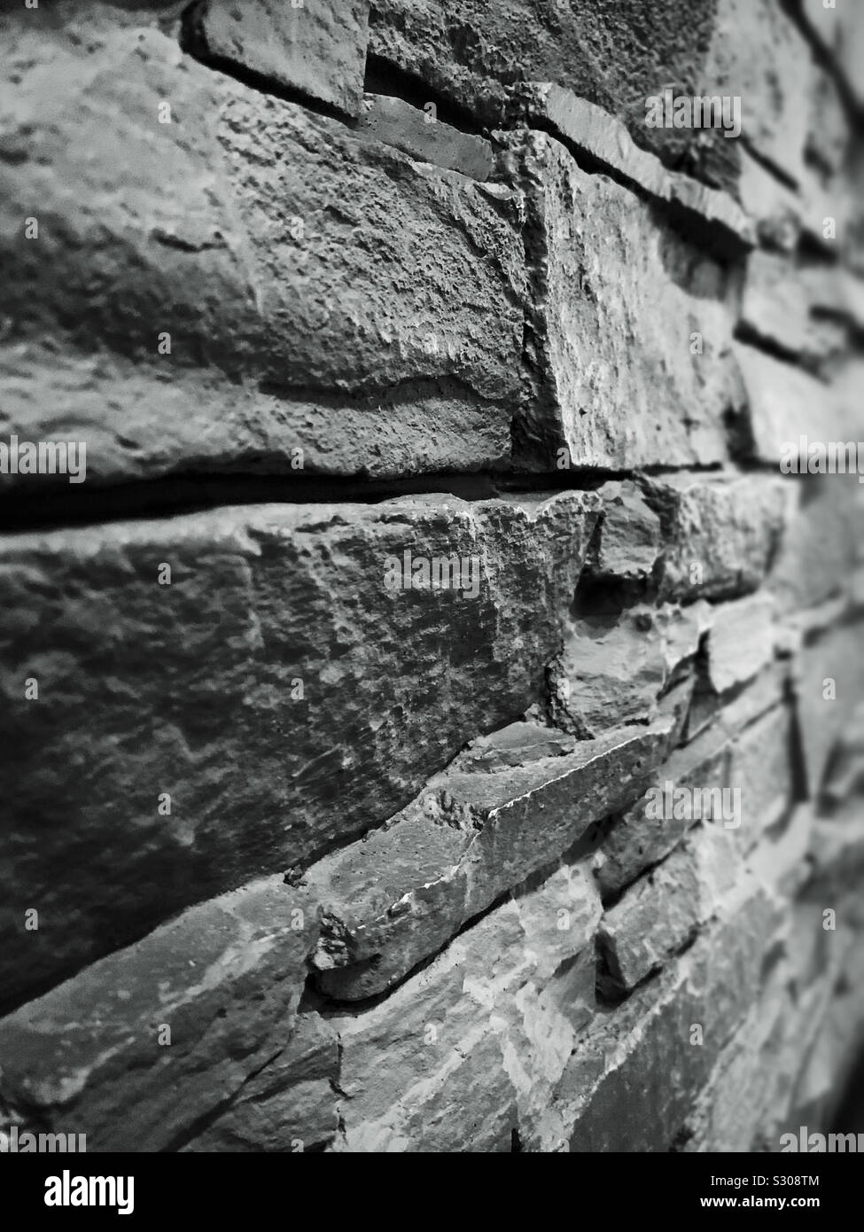 Steinmauer in Schwarz und Weiß. Detail und Textur - Smartphone-aufgenommenes Stockfoto