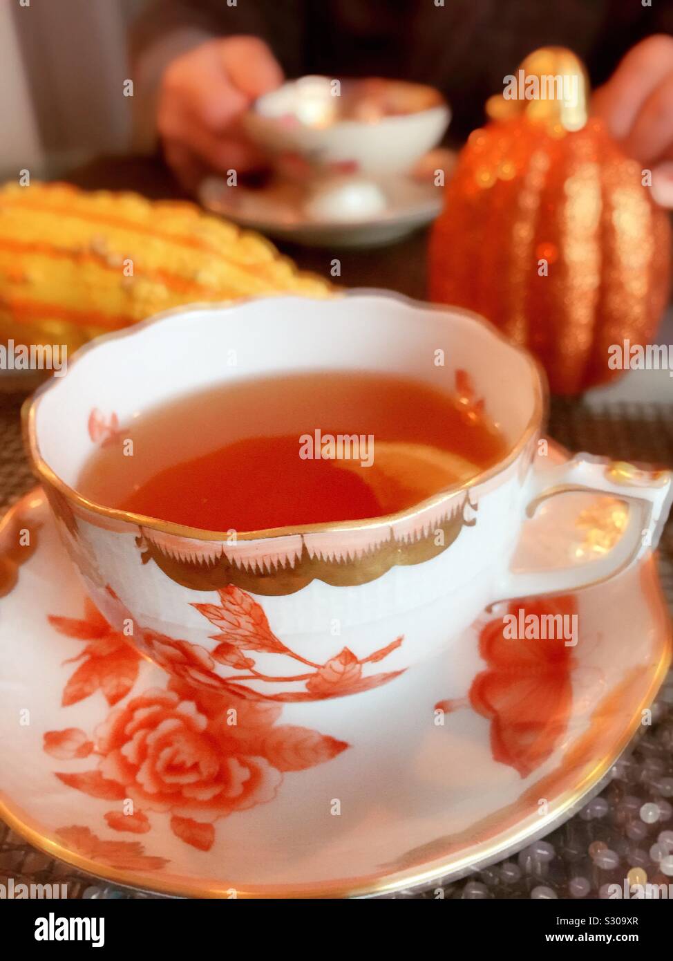 Ein feines Porzellan Tasse und Untertasse auf einen Herbst jahreszeitlich dekorierten Tisch - Smartphone-aufgenommenes Stockfoto