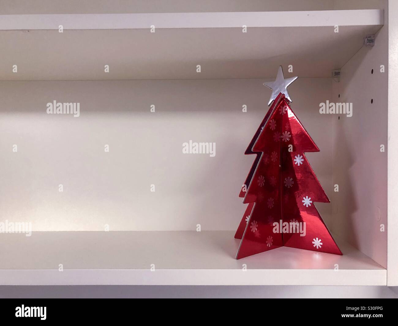 Karton rot Weihnachtsbaum auf einem leeren Regal. Stockfoto