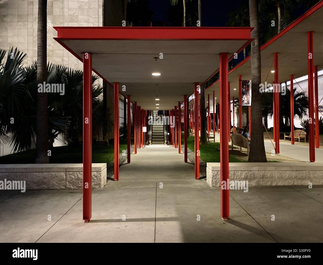 LOS ANGELES, Ca, November 2019: rot Beiträge support überdachten Gehweg führenden im Los Angeles County Museum der Kunst zu Rolltreppe Stockfoto