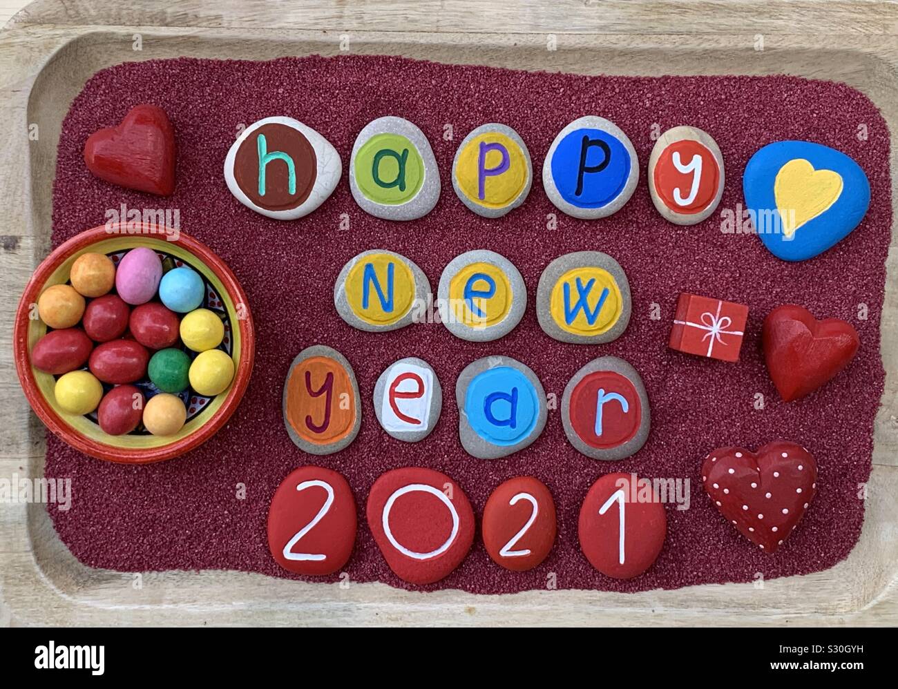 Frohes Neues Jahr 2021 mit einem kreativen Steine Zusammensetzung über roten Sand Stockfoto