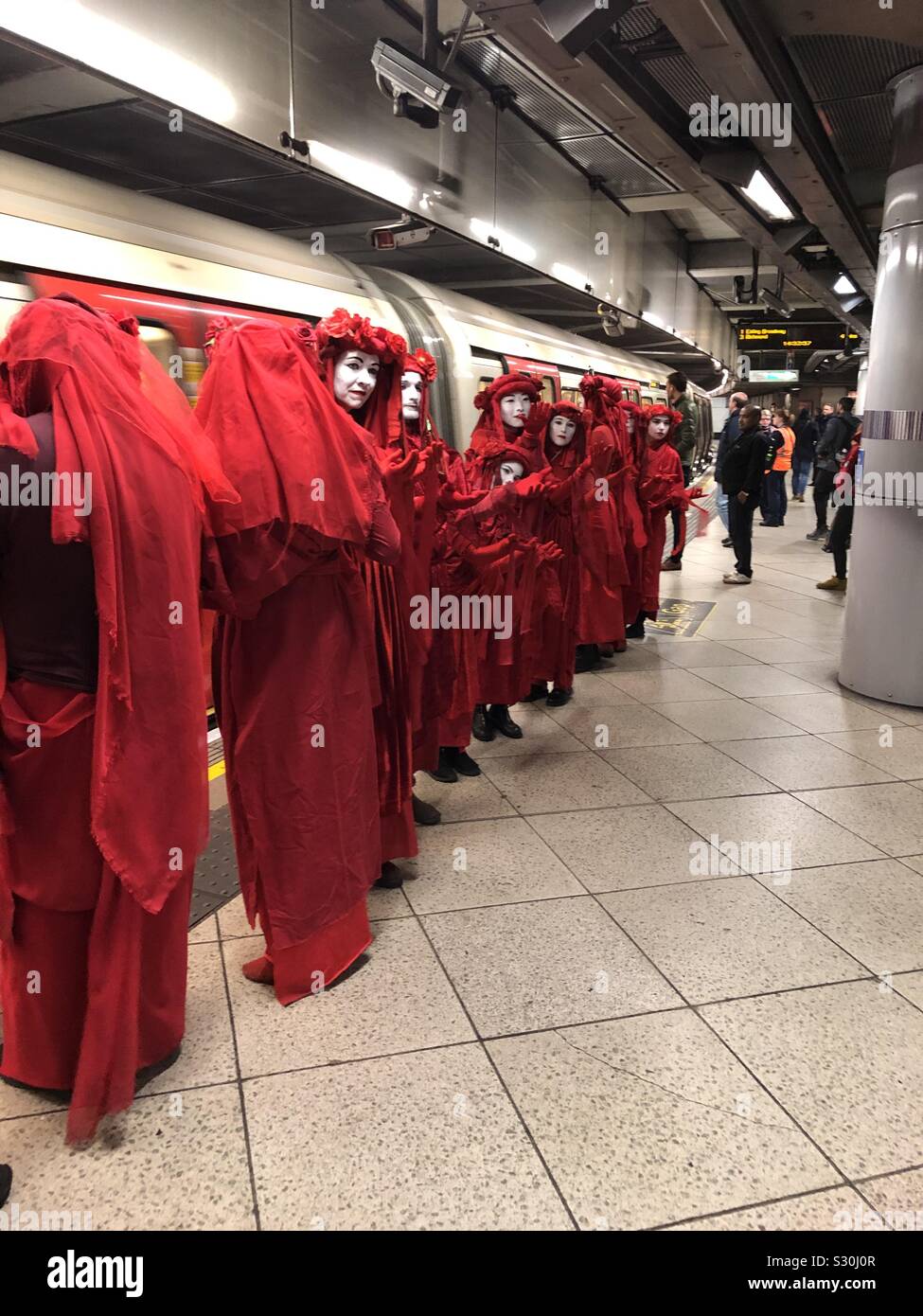 Die Rote Brigade des Aussterbens Rebellion auf einer U-Bahn Station Stockfoto