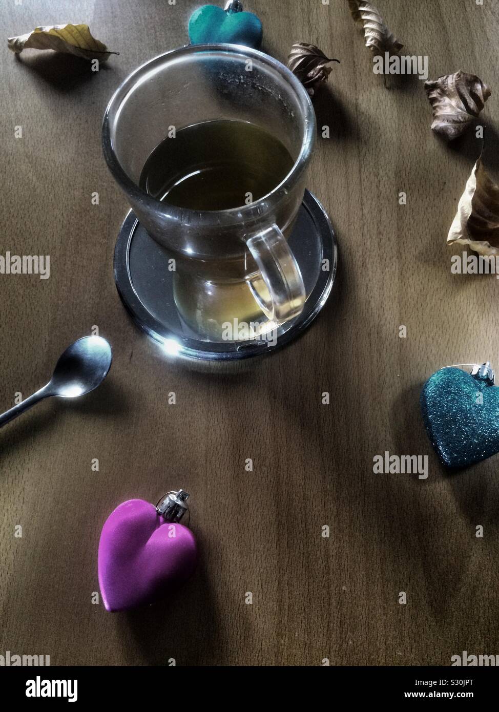 Close-up Tasse Tee mit farbenfrohen Herzen, getrocknete Blätter und Löffel. Stockfoto