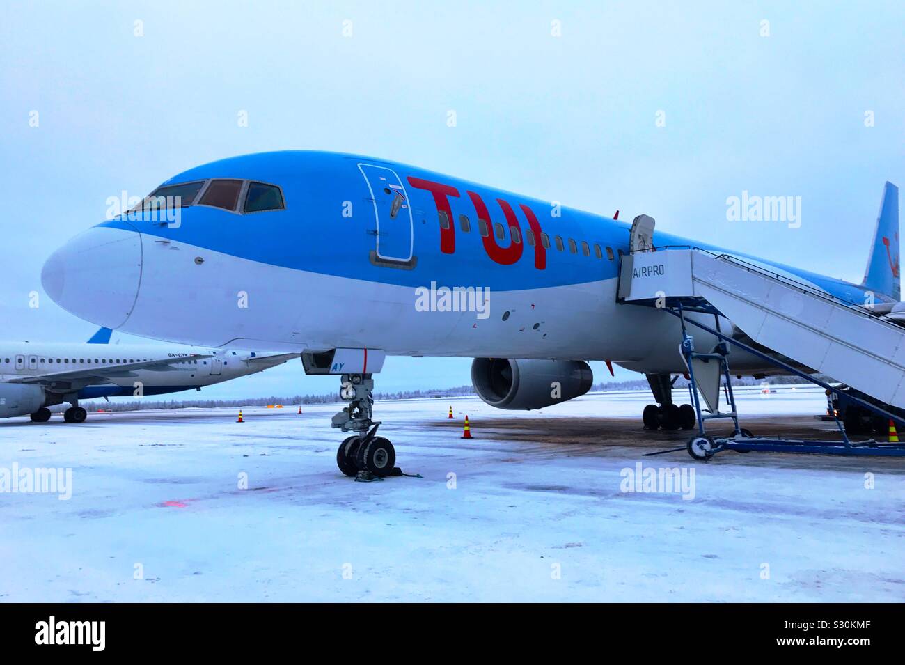 Tui Flugzeug Ankunft auf einem schneebedeckten Landebahn am Flughafen Rovaniemi in Lappland. Stockfoto