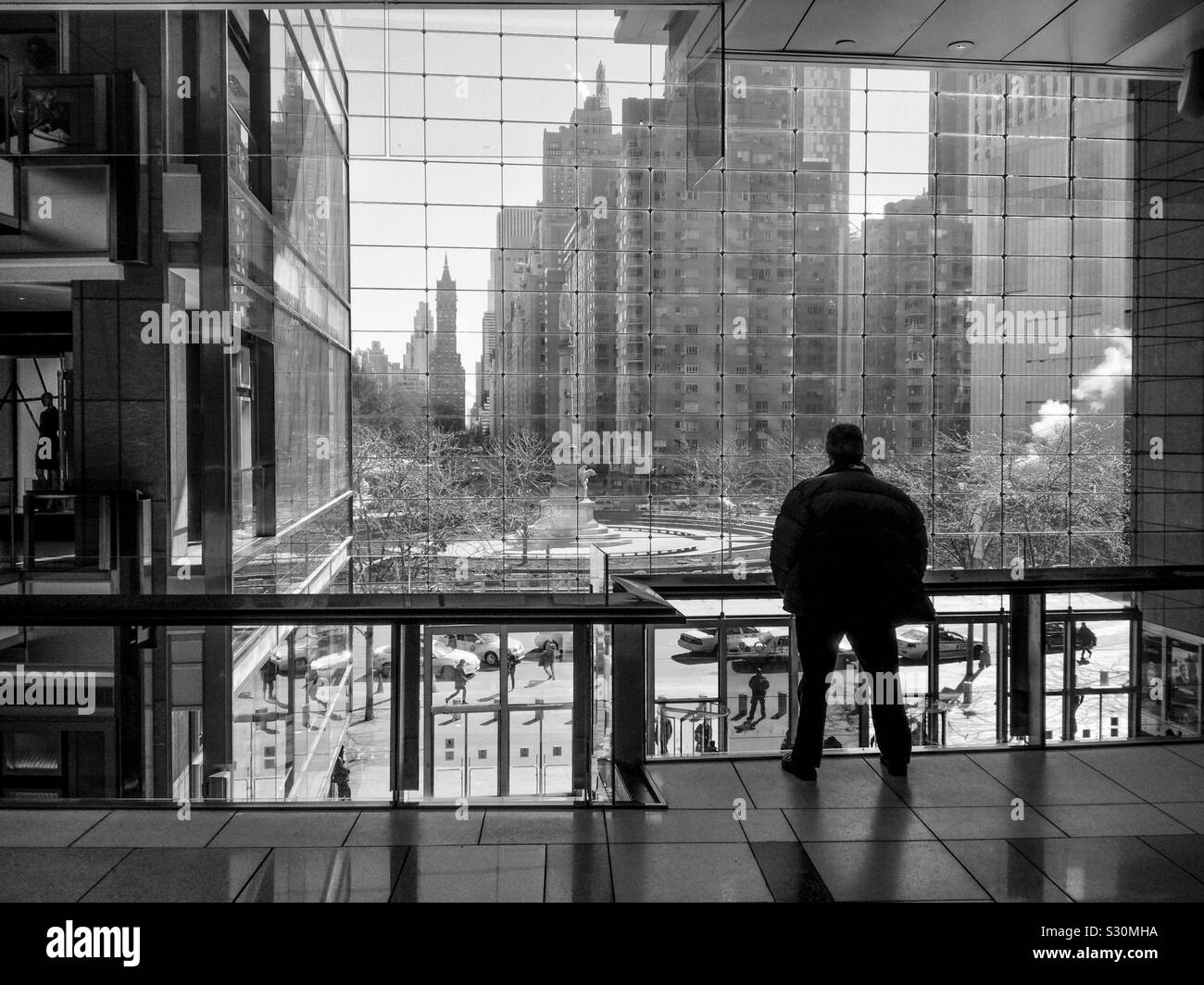 Mann in den Geschäften am Columbus Circle im Time Warner Center, in Richtung Columbus Circle, Manhattan, New York, USA. Winter 2014. Monochrom. Stockfoto