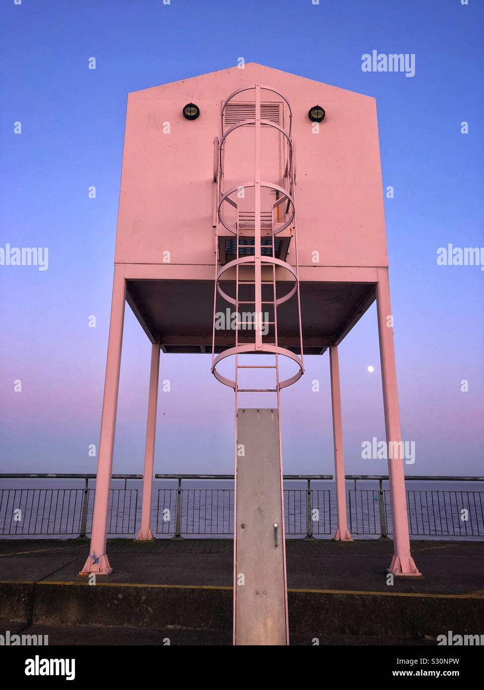 Big Pink Gebäude auf Cardiff Bay barrage mit aufgehenden Mond, Dezember. Stockfoto