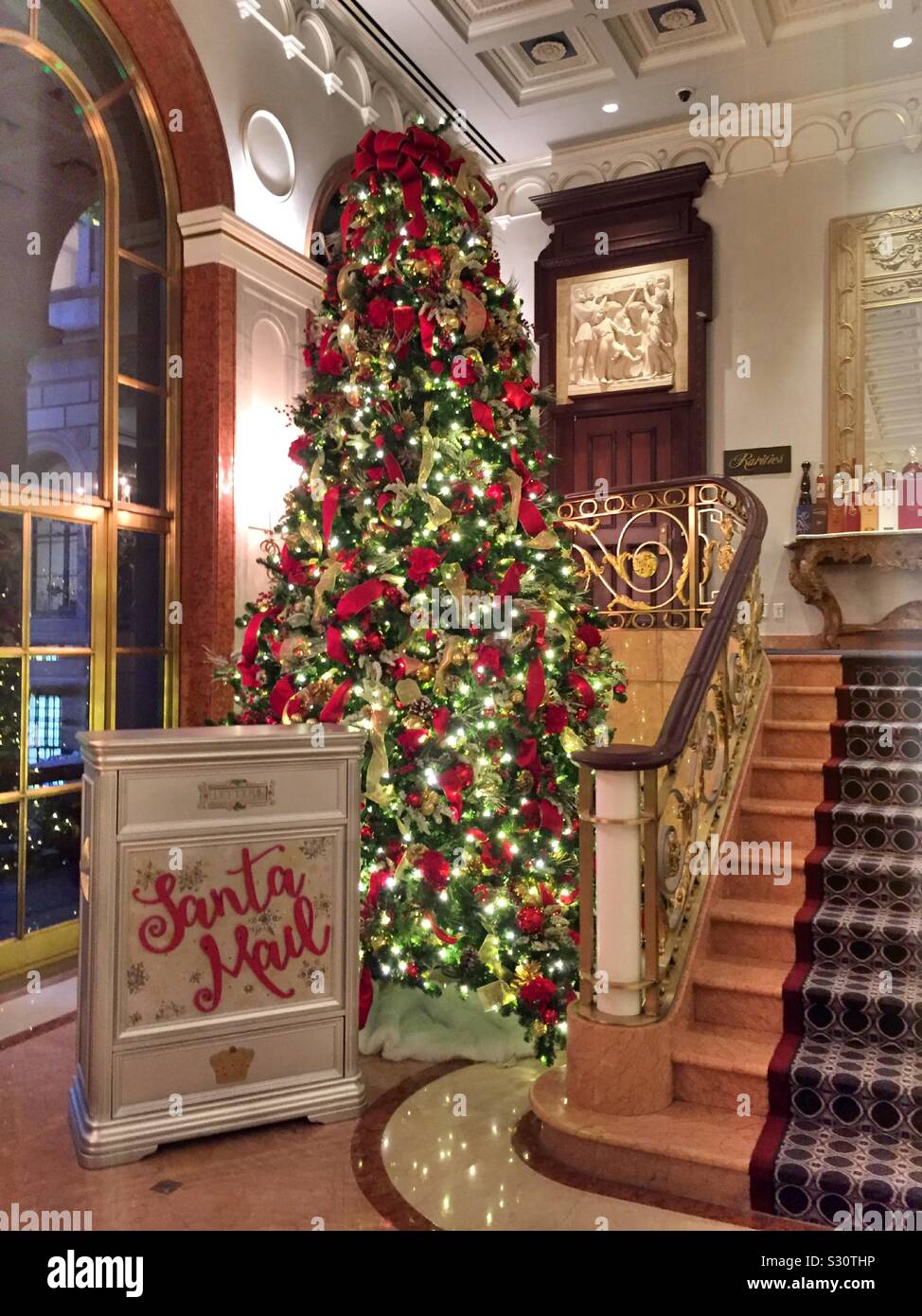 Die Lobby des Lotte Palace Hotel verfügt über eine Mailbox zu Santa und hell dekorierte Weihnachtsbäume während der Ferienzeit, NYC, USA Stockfoto