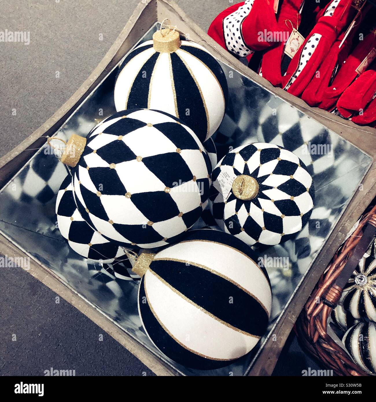 Klassisch schwarz und weiß Harlekin themed Weihnachtsverzierungen in einem gespiegelten Box Stockfoto