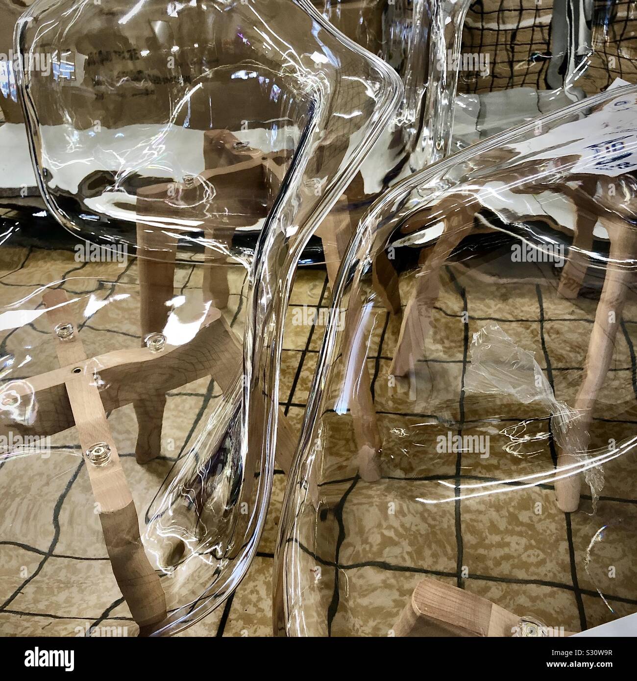 Verzerrte Ansicht aus transparentem Kunststoff Stühle. Stockfoto