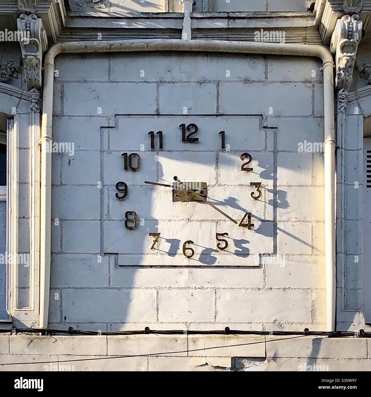Alte Uhr mit Schatten von Ziffern auf Gebäude aus Stein, Chatellerault, Vienne, Frankreich. Stockfoto