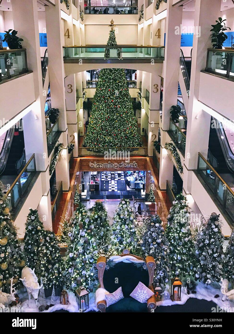 Weihnachtsbaum und Dekorationen mit Santa Claus Stuhl an einem Einkaufszentrum auf der Michigan Avenue, Chicago, Illinois Stockfoto