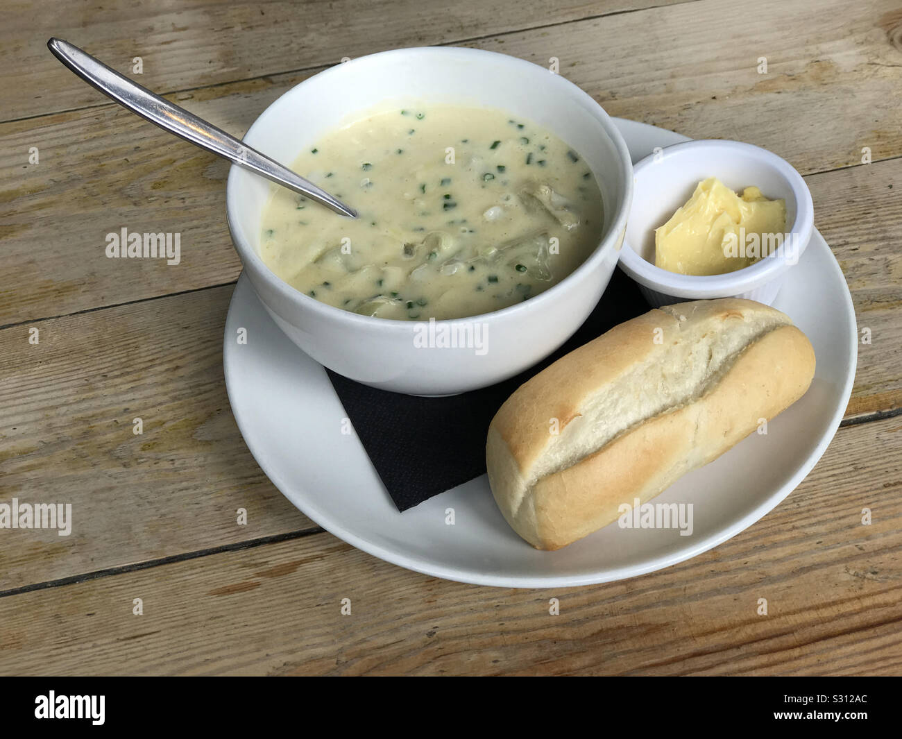 Cullen Skink traditionelle schottische Suppe gezeigt, mit weißen Fisch, Kartoffeln, Zwiebeln und Milch. Brot und Butter werden auf der Seite angeboten. Stockfoto