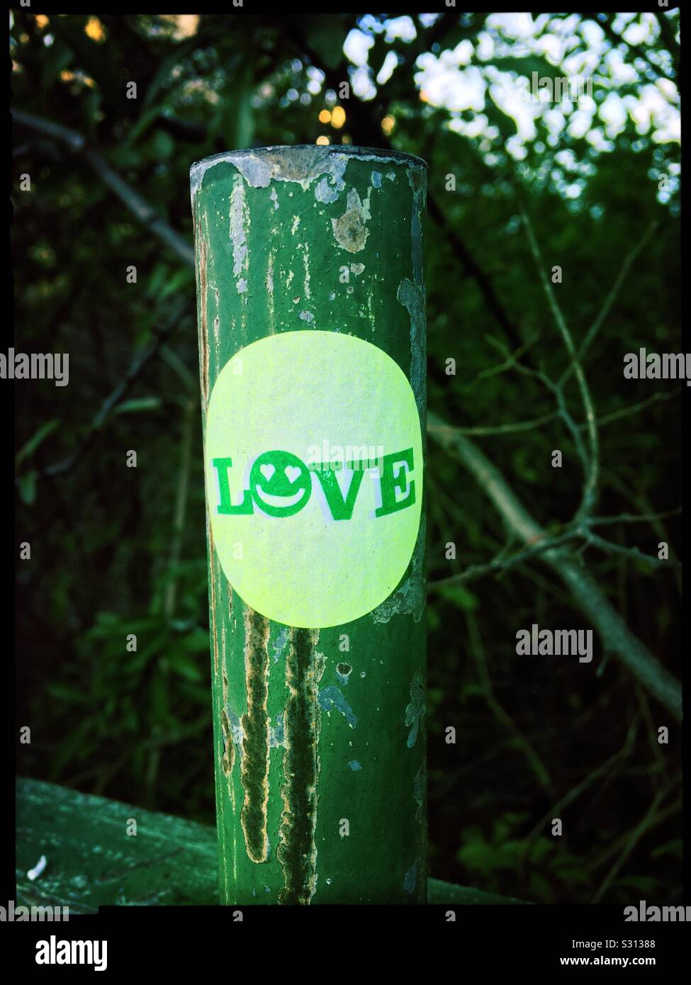 Ein Aufkleber mit dem Wort Liebe auf einem Zaun Post In der Stadt Stockfoto