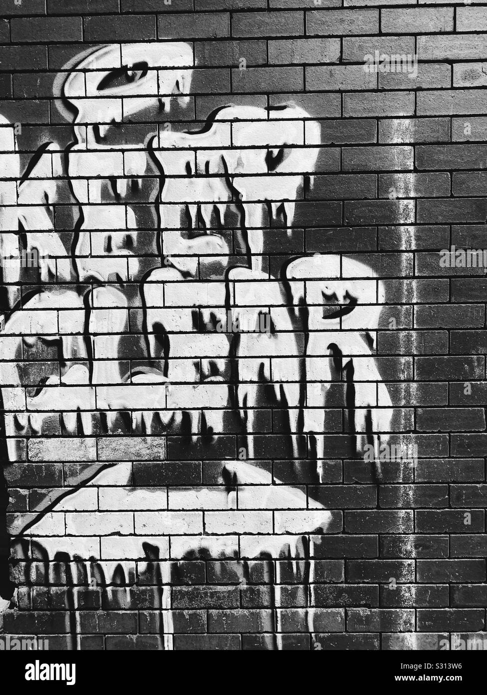 "Abstand halten" geschrieben Graffiti in Mauer in Schwarz und Weiß. Stockfoto