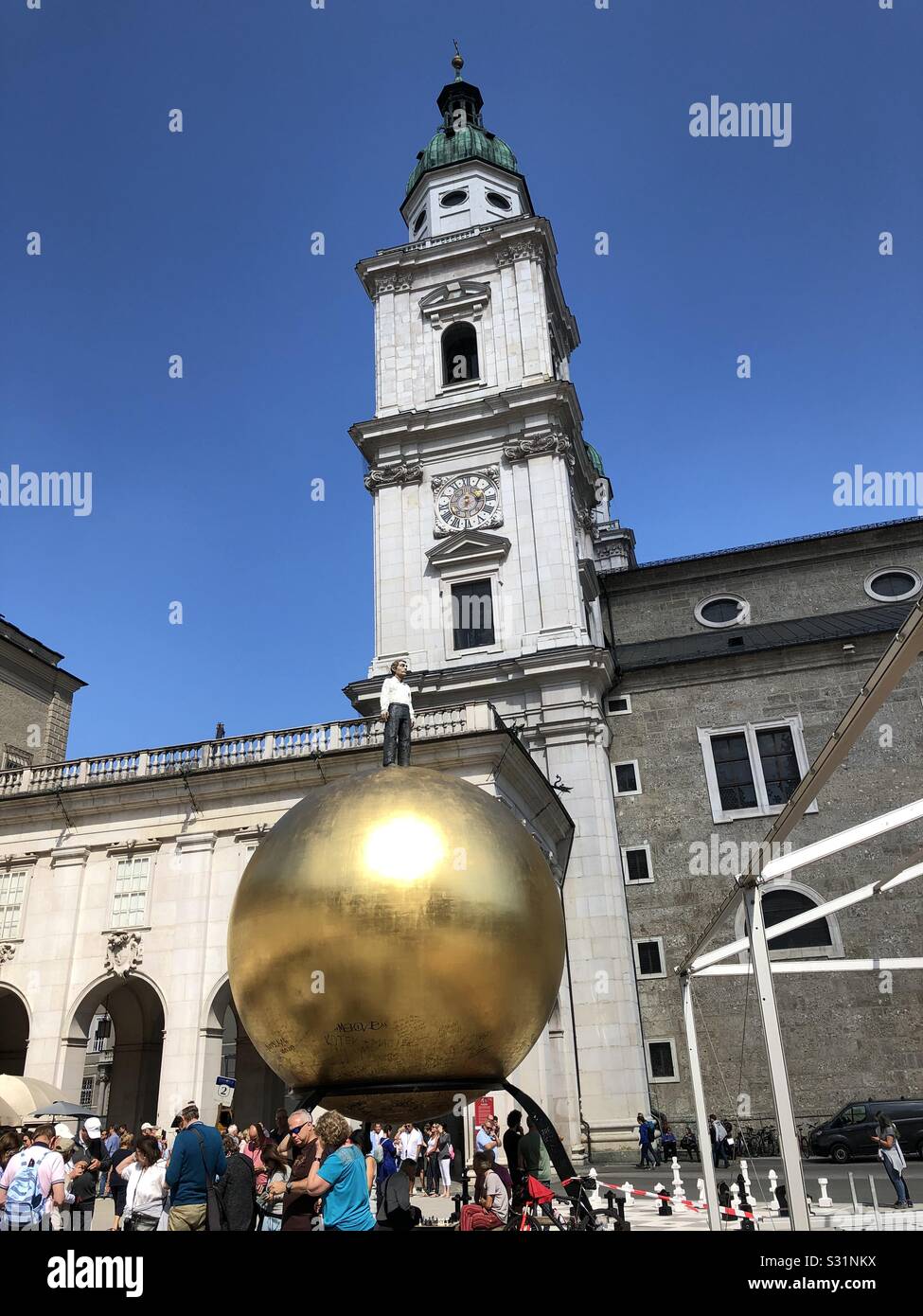 Mann auf einen Golden Globe Statue - "Walk of modern art" in Salzburg, Österreich. - Smartphone-aufgenommenes Stockfoto