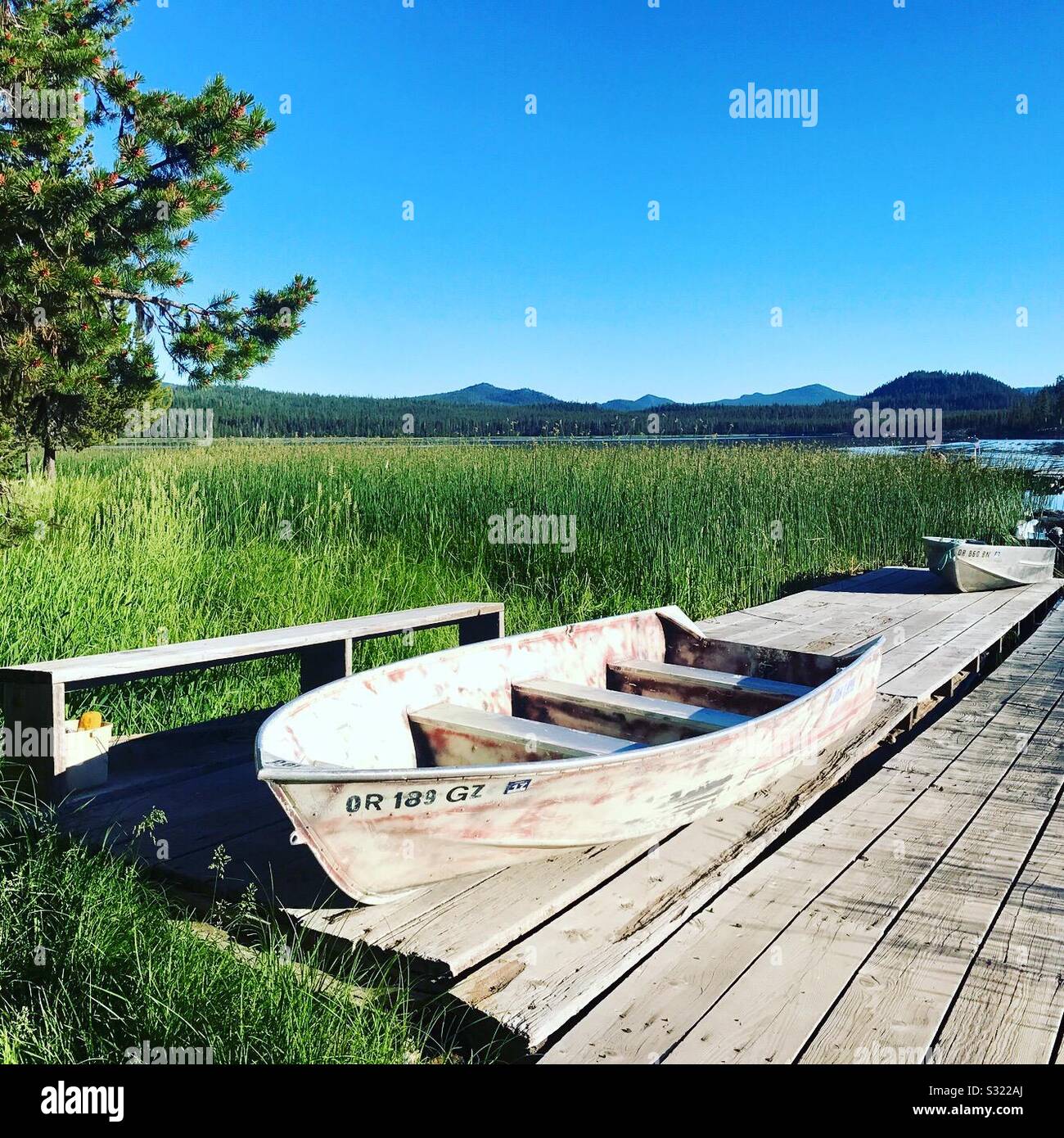 Lakeside Landschaft mit angedockten Holz- Boot- und Bergblick ist Stockfoto