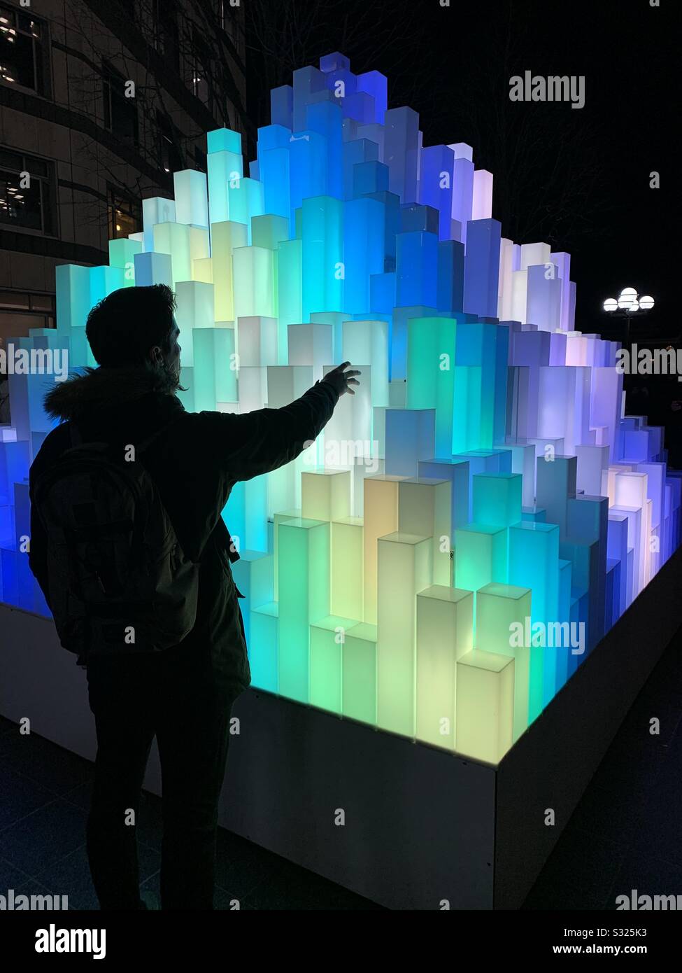 Der Mann, der sich mit der Installation von Pyramidenlicht an der Winterbeleuchtung Canary Wharf Januar 2020 einlädt Stockfoto