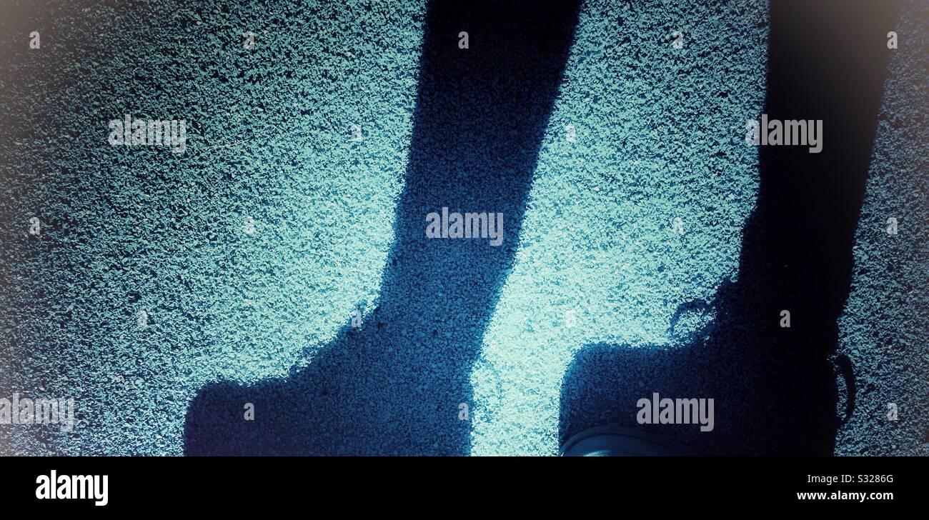Fußgängerfüße Schatten auf der Straße - Smartphone-aufgenommenes Stockfoto