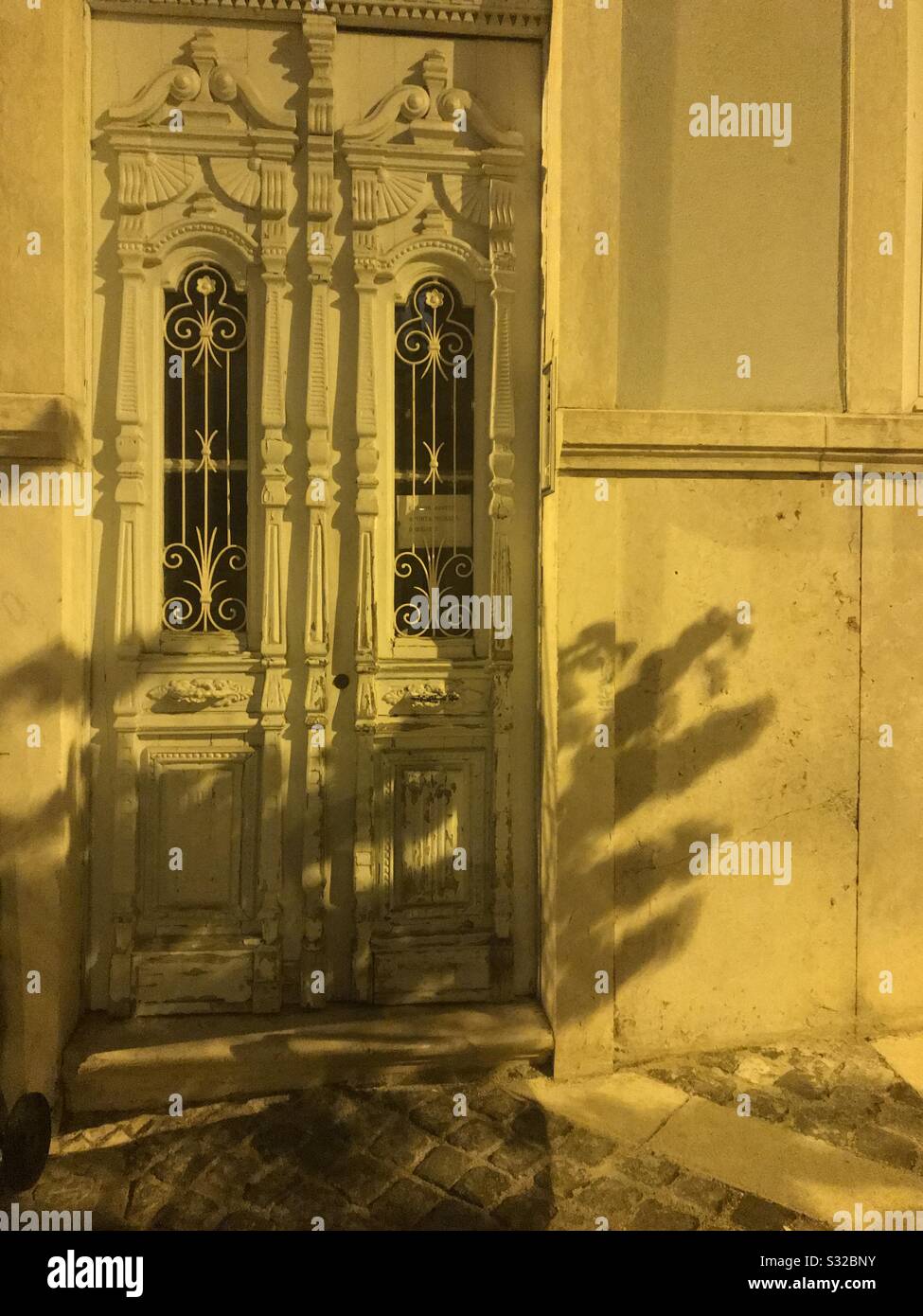 Tür in Schatten bei Nacht mit gelben Lichtreflexionen Stockfoto