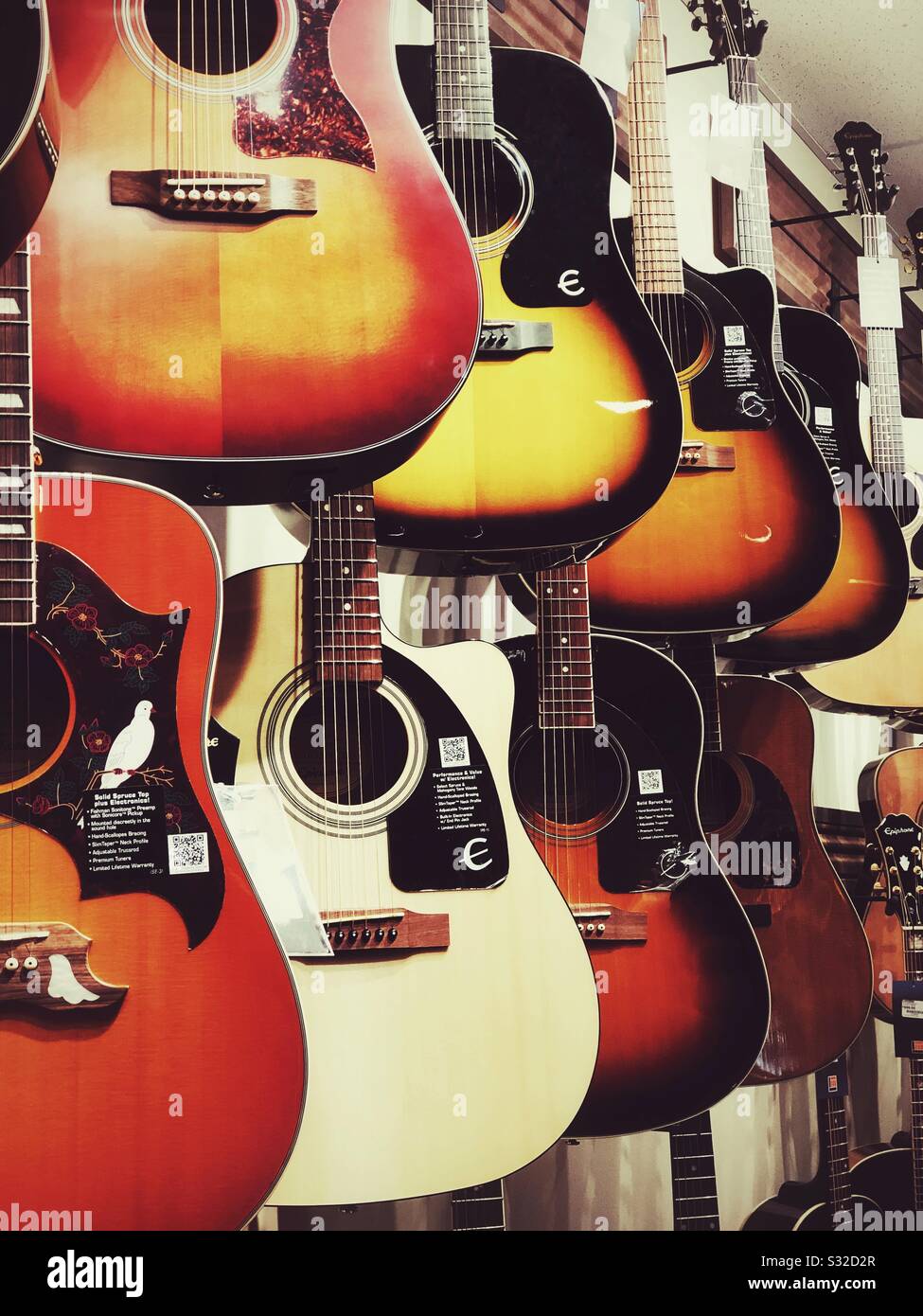 Akustische Gitarren hängen an der Wand im Musikladen zum Verkauf Stockfoto