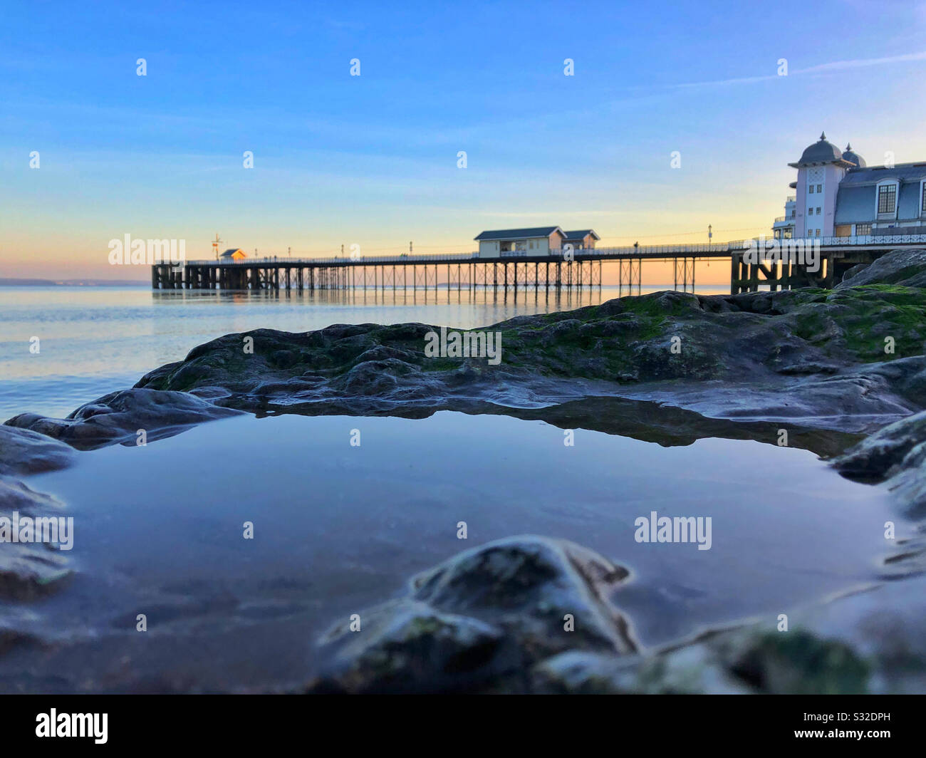 Penarth Pier in der Dämmerung mit Vordergrund-Rockpool, South Wales, Januar. Stockfoto