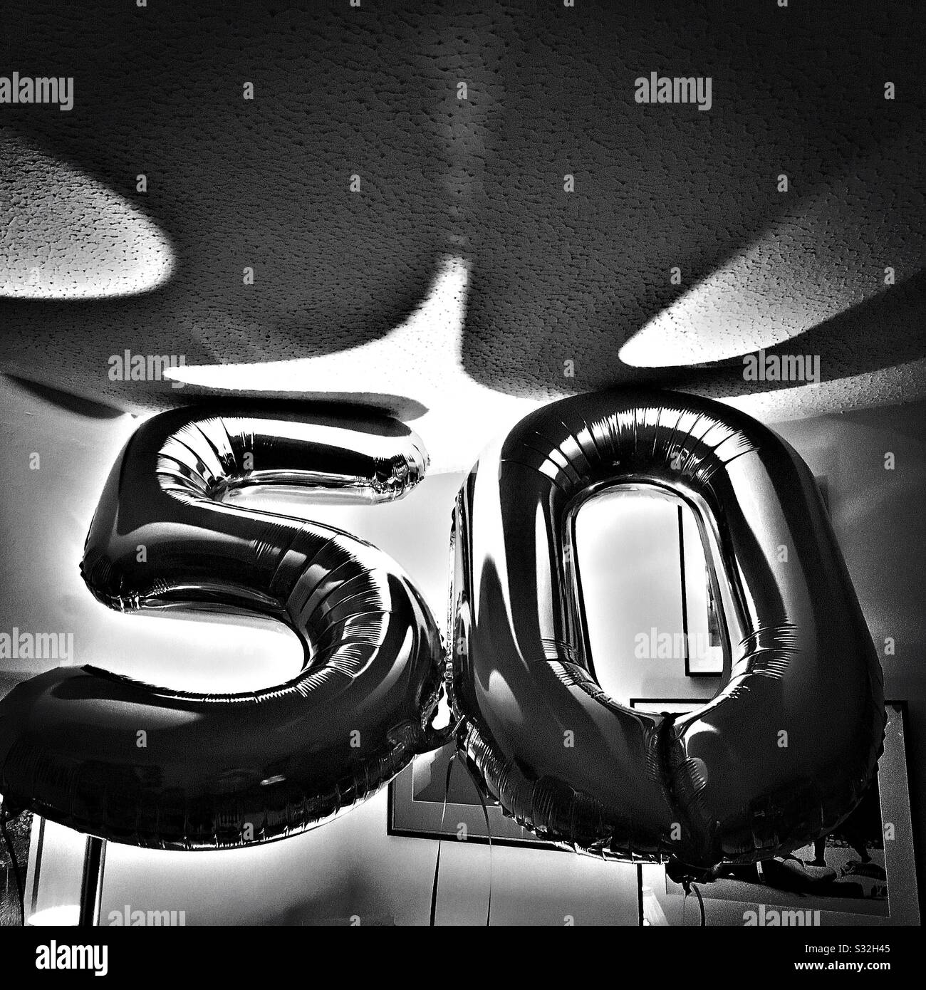 50. Geburtstag Ballons in Schwarzweiß mit Schatten an der Decke Stockfoto