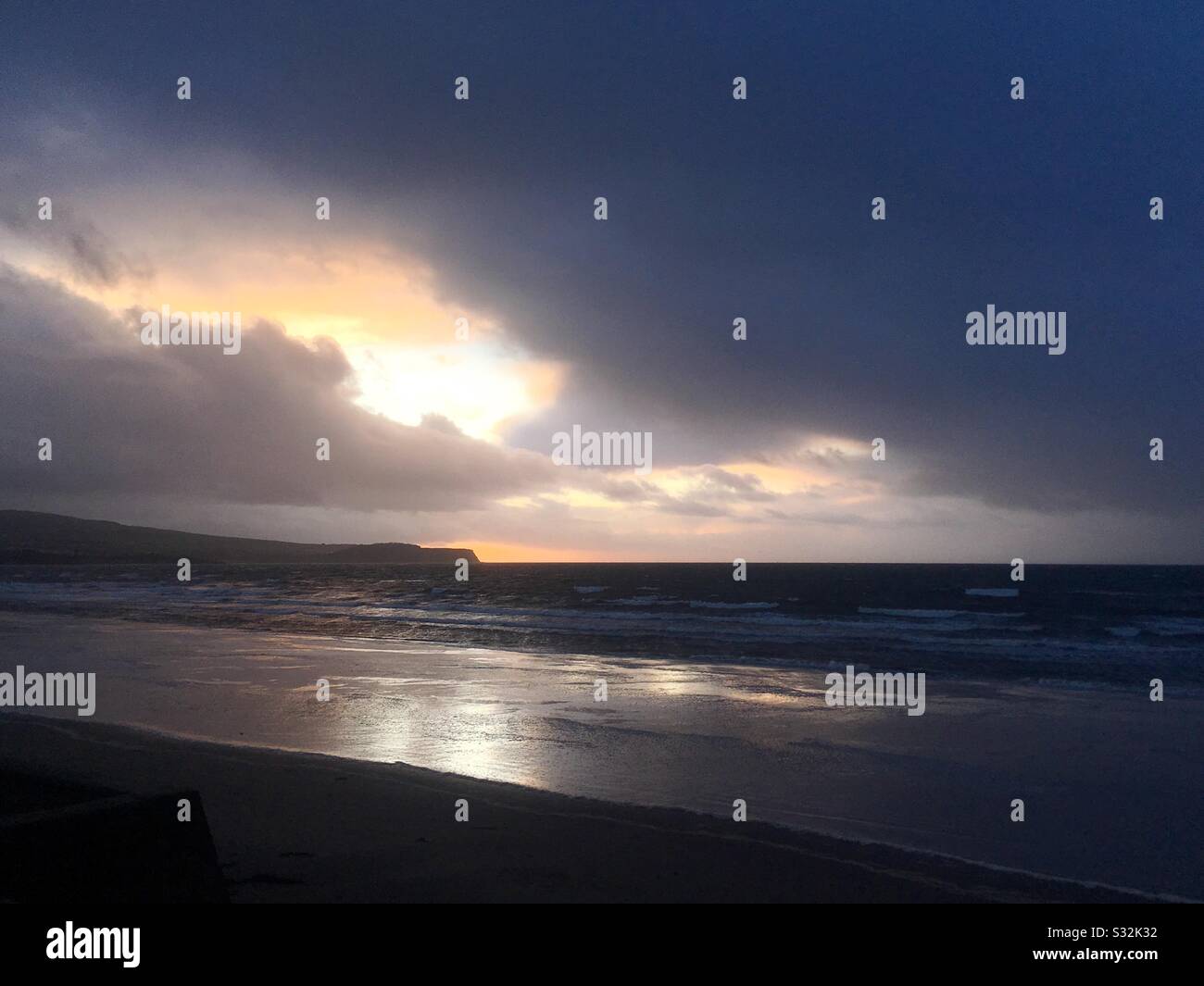 Ein Bruch in den Sturmwolken über Ayr Beach bei Sonnenuntergang Stockfoto