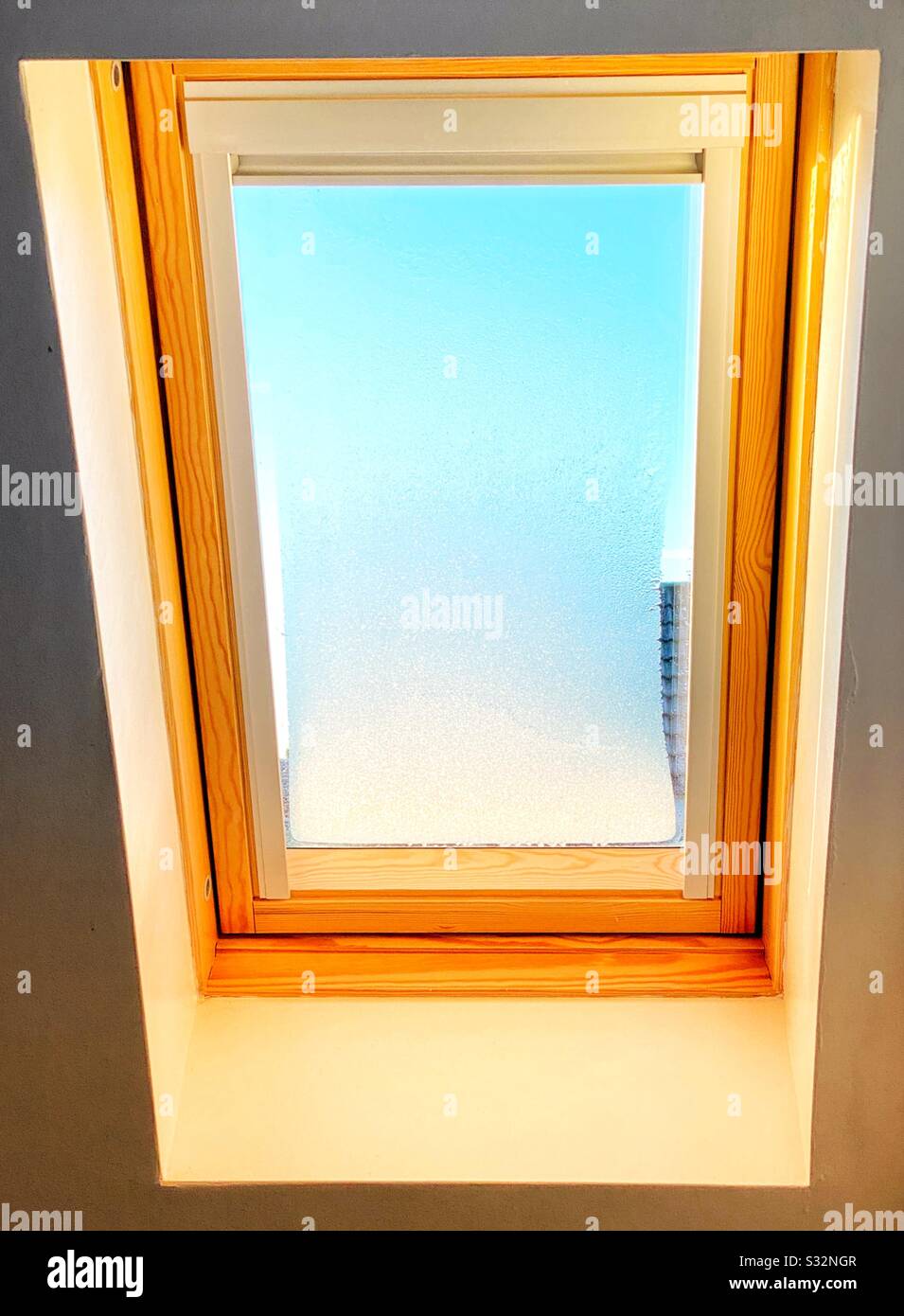 Oberlicht mit Milchglas am frühen Morgen Sonnenlicht an einem kalten Wintermorgen - Smartphone-aufgenommenes Stockfoto