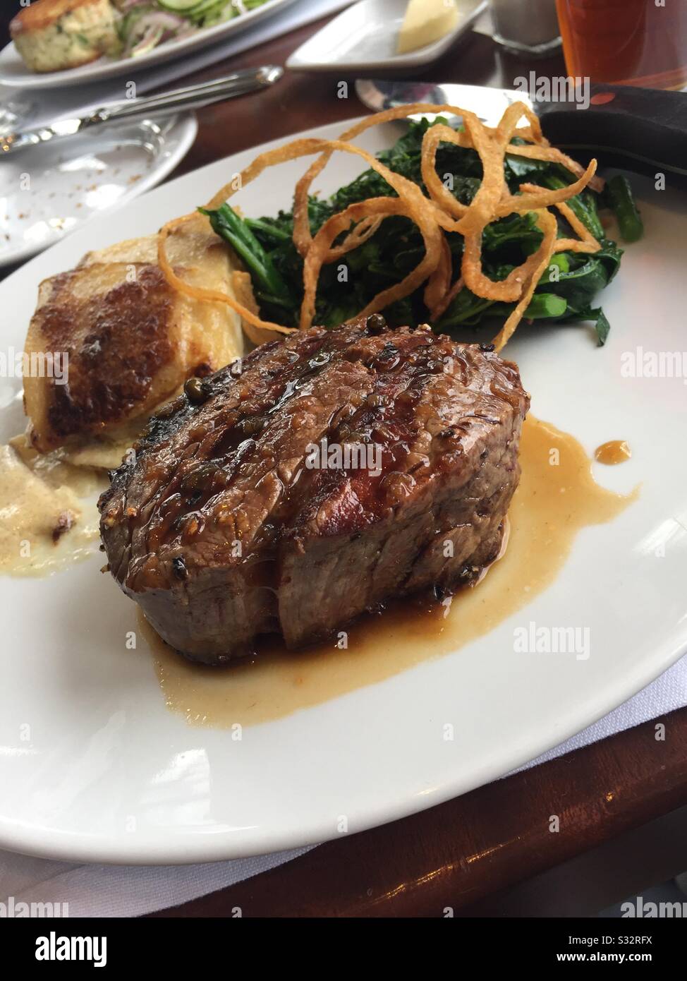 Gourmet-Entrée aus gegrilltem Blattfilet mit Süßkartoffel, Spinatsalat mit Pilzen, Blaukäse und eingelegtem Fresno-Pfeffer, New York City, USA - Smartphone-aufgenommenes Stockfoto