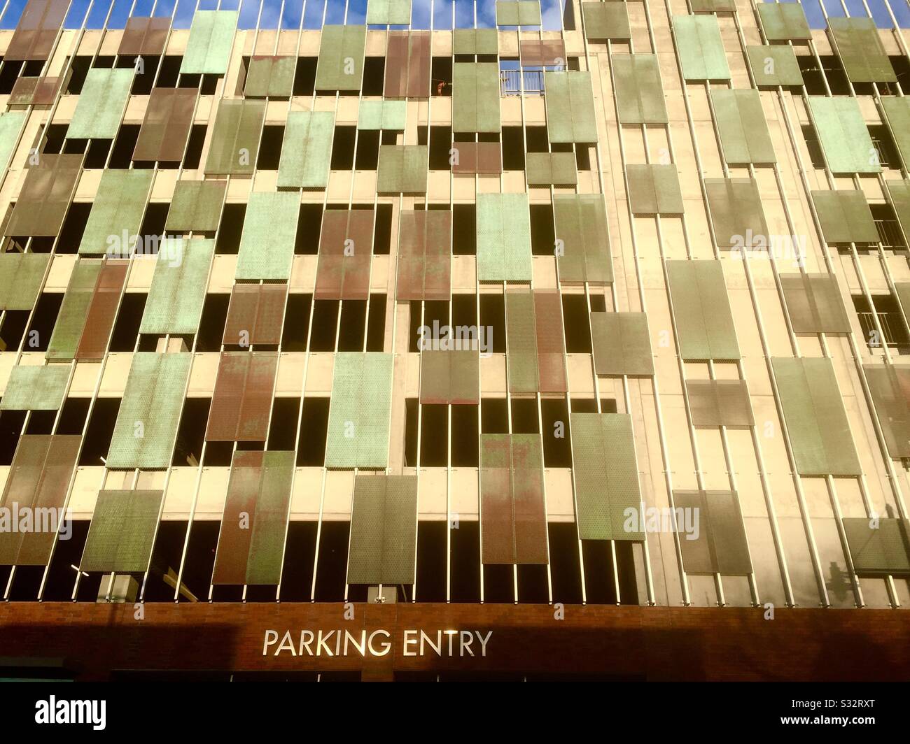 Parkplatz mit interessantem modernem Kunstdesign, Linien, Rechtecken und architektonischen Verkleidungen mit Park-Einstiegsschild. Emeryville, Kalifornien. - Smartphone-aufgenommenes Stockfoto