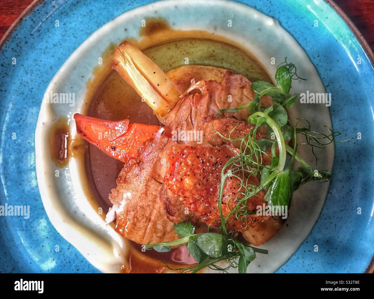 Mittagessen am Sonntag: Schweinebraten, Knistern, Gemüse braten, Püree schnuppern und einen Pfirsich angarnieren. - Smartphone-aufgenommenes Stockfoto