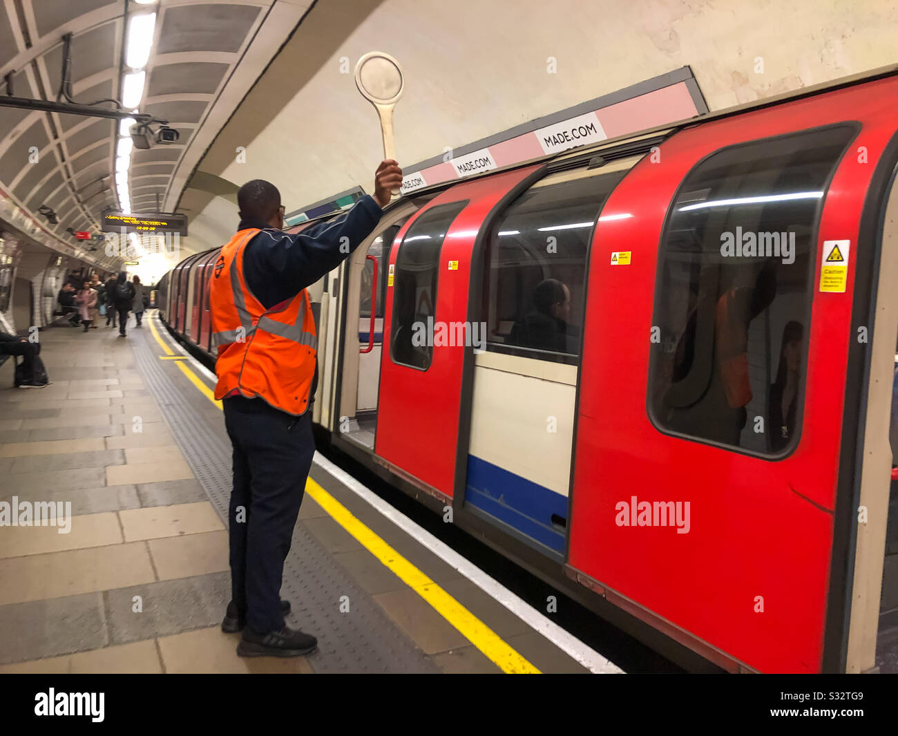 Ein Wachmann schickte einen Zug auf Die Londoner U-Bahn. Stockfoto