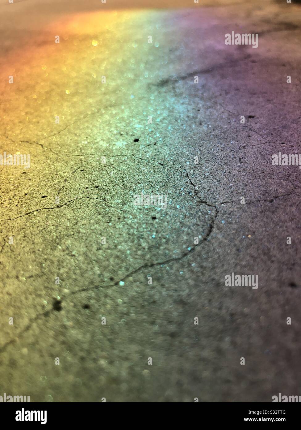 Ein Regenbogen, der auf gebrochenem Beton aus Licht durch Glas gegossen wurde. Stockfoto