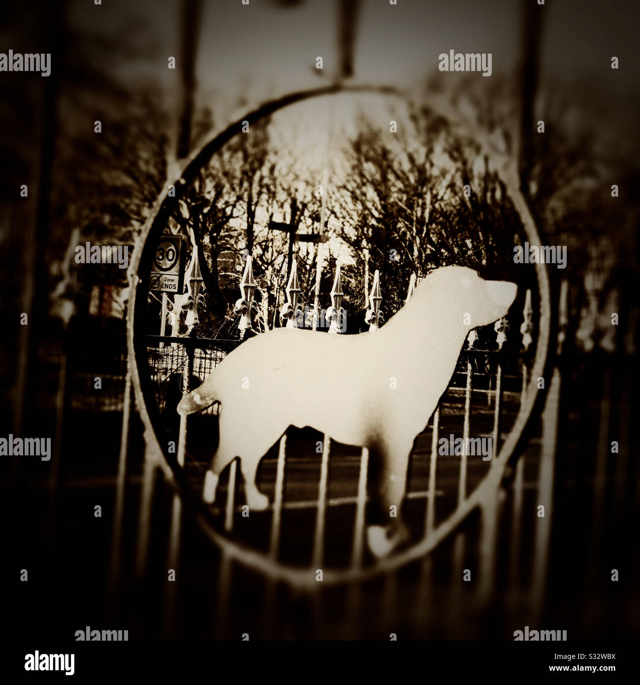 Die Form eines Hundes auf einem schmiedeeisernen Tor - Smartphone-aufgenommenes Stockfoto